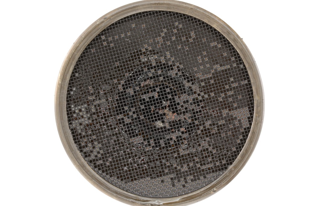 deposits and sludge accumulated in the openings of oil pickup tube screen from engine oil 